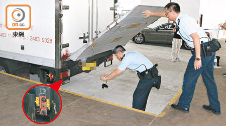 警員檢查肇事貨車尾板。圓圖為車尾旁的尾板操作器。（曾紹良攝）