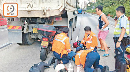 電單車插在泥頭車底，休班警長重傷昏迷，圖右為協助救援的休班救護員。（陳錦昌攝）