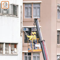 工人清理大廈外牆有剝落危險的批盪。