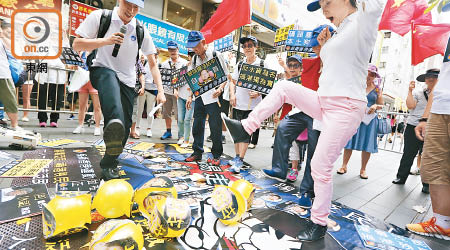 有參與者踢走兼踩爛貼有泛民議員肖像及垃圾字眼的氣球，呼籲市民以選票踢走泛民。（蘇文傑攝）