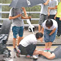 有人落車打傘替傷者擋雨。（互聯網圖片）