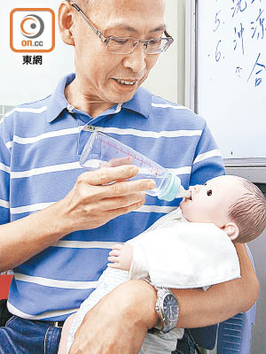 報讀課程後，梁先生已純熟掌握為嬰兒餵奶的連串動作。（黃偉邦攝）