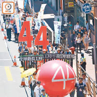 遊行人士以印有「44」的紅色氣球打頭陣，爭取標準工時立法。（蕭毅攝）
