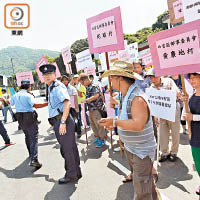 村民手持標語抗議政府未有就劃地諮詢村民，剝奪私人土地權益。