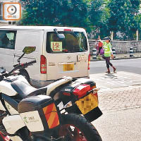 天光道<br>身穿反光衣的「場務員」在路口為考試車輛攔車。