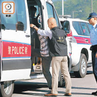 移交後<br>香港警方替疑犯重新鎖上手銬後，再將他押上警車帶走。