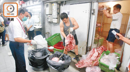 食環署昨在上環街市將凍倉內逾一千公斤豬肉灑上消毒粉，用垃圾桶運走銷毀。（高嘉業攝）