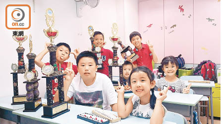 八名在吉隆坡珠心算競賽獲獎的小朋友與戰利品合照。（關琛詩攝）