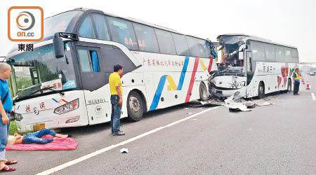 被撞的大巴車前有一名傷者臥地待援。（讀者提供）