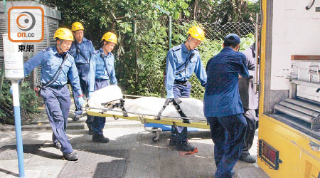 仵工將遺體舁送殮房。（曾志恒攝）