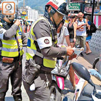 泰國警方在布吉遊客區設置路障，檢控沒有佩戴頭盔的電單車駕駛者。（受訪者提供）