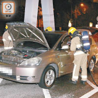 涉案私家車焚毀，消防到場將火救熄。（王偉安攝）