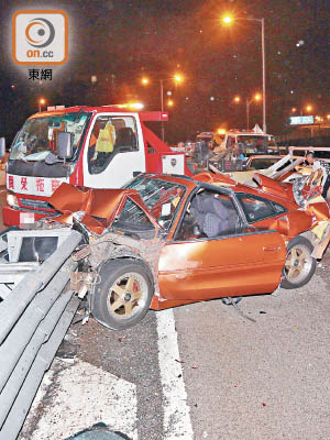 肇事跑車猛撞防撞欄，全車盡毀。（王偉安攝）