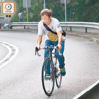 一名騎單車人士在澳景路上山時乏力，單車左搖右擺。