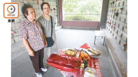 羅女士（右）帶同先人喜愛的可樂及鬆糕到場拜祭，又指若附近規劃適合可考慮每區都有骨灰龕場。