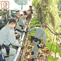 警員到洋房後的山坡搜索。（黃永健攝）