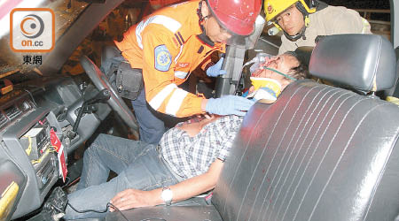 消防員及救護員拯救受傷被困的士司機。（胡德威攝）