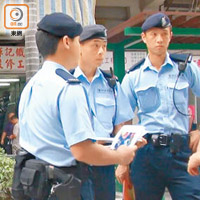 警員手持女童照片向街坊查問。（張開裕攝）