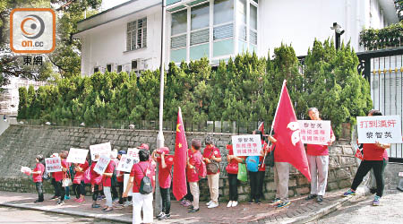 穿紅衣嘅人士手持標語喺漢奸黎寓所外示威，怒轟漢奸黎係千古罪人。
