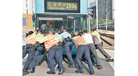 警員及港鐵職員合力推動跪低九巴。（互聯網圖片）