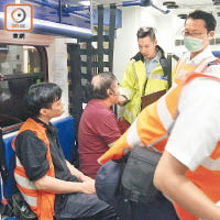 受傷的士司機（左二）在救護車上接受治療。