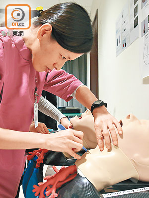 學員學習在「病人」咽喉位置開設人工造口，導師從旁指示手勢、落刀位置等。
