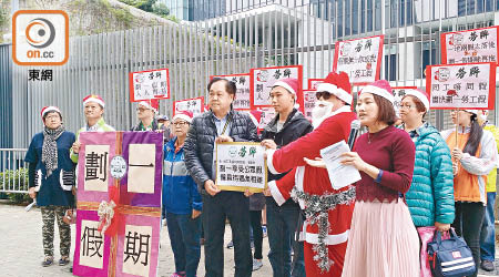 約二十名工人穿上聖誕服裝到政府總部請願，爭取落實劃一十七日僱員假期。（關琛詩攝）
