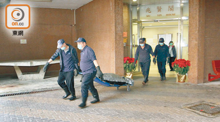 輕生青年的遺體由仵工舁送殮房。（文健雄攝）