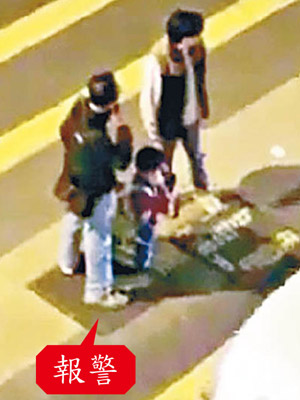 男童在馬路上扭耳仔跪行時其父在旁（右），男途人打電話報警。（互聯網圖片）