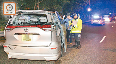 打觔斗七人車損毀嚴重，司機（右二）在場調查。（吳建明攝）