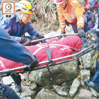 死者遺體由消防員抬落山。（張世洋攝）