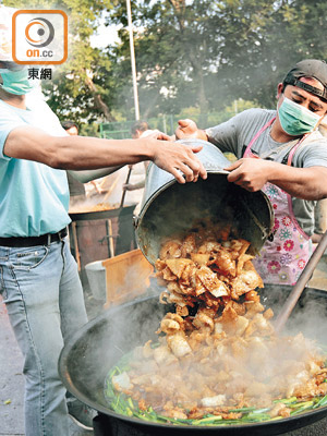 「大廚」鄧文龍（右）為準備盆菜宴，早上六時開始煮食。（胡家豪攝）