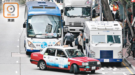 有旅遊巴和的士於車路中央上落客。（梁耀榮攝）