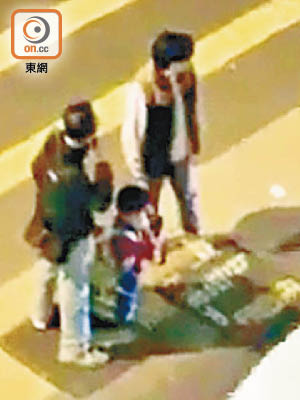 李姓男被告（背心外套）事發時罰兒子跪着過馬路，遭男途人報警揭發。