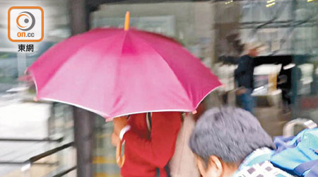被告楊家倫（紅傘紅衣）昨離開時以雨傘掩臉。