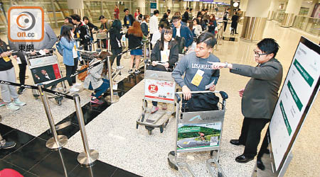 機場職員採取人流管理應變措施，協助在旅客登記區域等候的旅客。（讀者提供）