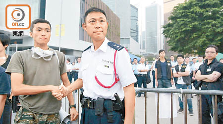 楊逸朗（左）在佔領行動期間曾與警方代表握手合照，成為經典場面。