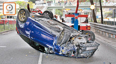 跑車撞欄後翻轉。（劉子文攝）