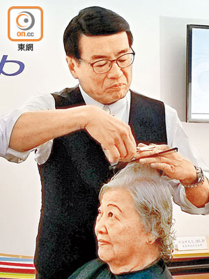 梁永祥即席幫一位婆婆剪頭髮，剪得有板有眼。（佘君儀攝）