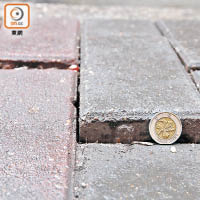 有數塊面向馬路的石磚整排凸出，部分高約一個十元硬幣。