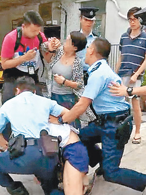 男居民被警員壓在地上，女居民則與在場公職人員發生碰撞。（互聯網圖片）