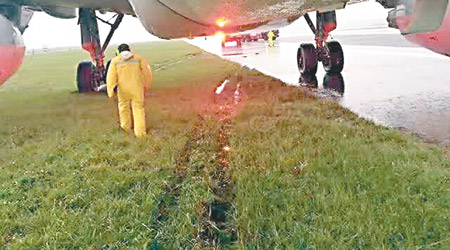 涉事中國東方航空客機，在暴雨期間滑出跑道衝上草坪，傳維修人員在現場檢查。（互聯網圖片）