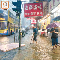 西環<br>西環東邊街水淹道路，人車涉水而行。