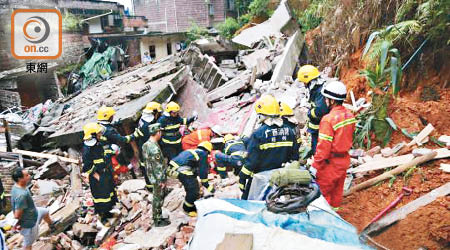 廣西<br>救援人員在塌樓房現場搜救被埋居民。