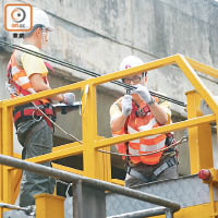 工程人員在高台車上近距離檢測架空電纜。