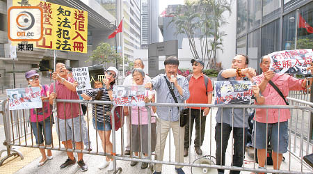 約十名反梁國雄市民到庭外示威，並高舉「知法犯法　送佢入冊」橫額。