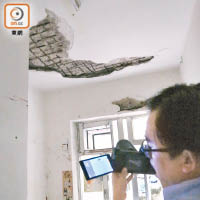 樓宇檢測專家使用紅外線掃描器檢測附近單位的樓宇狀況。