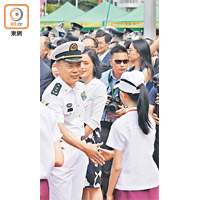 中國解放軍海軍副司令員兼航母編隊指揮員丁毅（左）與歡迎隊伍的學生代表握手。