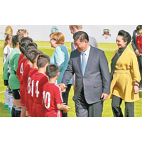 日前習近平訪德，和身穿黃色大衣的彭麗媛一起會見少年足球員。