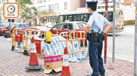 疑遭虐殺流浪貓棄屍街頭，警員用紙盒遮蓋。（吳建明攝）